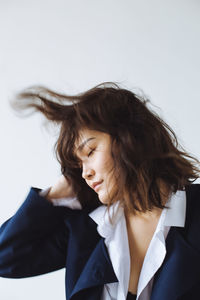 Young woman standing against white background