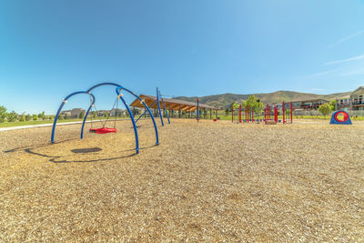 View of playground on beach against clear blue sky