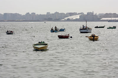 Sailboats moored in sea against clear sky