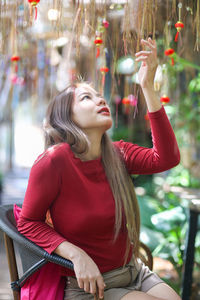 Woman looking away while sitting outdoors