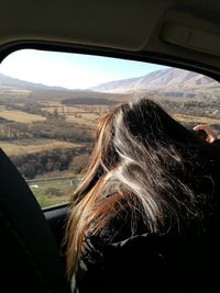 Woman seen through car window
