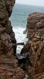 Rock formation on beach against sky