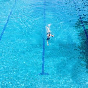 High angle view of athlete swimming in blue pool