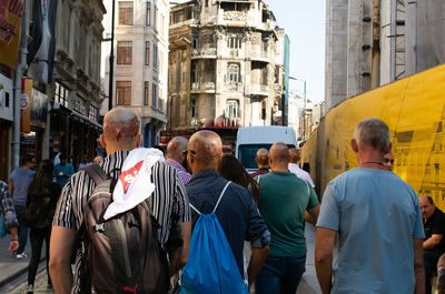 Rear view of people walking on street in city