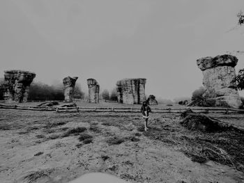 Man walking on field against clear sky