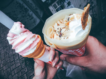 High angle view of hands holding ice cream cone