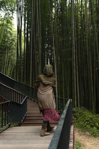 Rear view of woman walking in forest