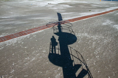 Shadow of person on sand during sunny day