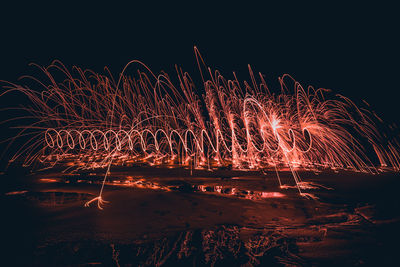 Firework display against sky at night