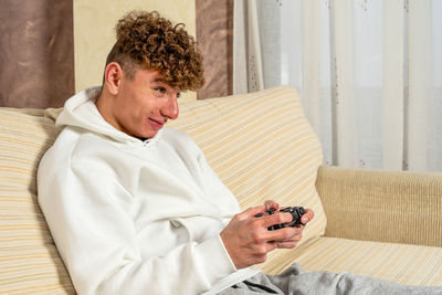 Side view of senior man sitting on bed at home