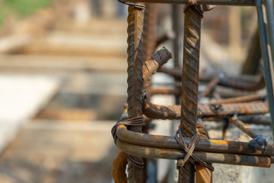 Close-up of rusty chain tied up on metal