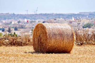 Hay bales on field against sky