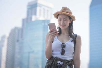 Young woman using mobile phone in city