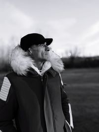 Mature man standing on field against sky during winter