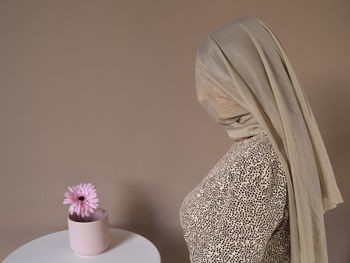 Close-up of white flower on table against wall