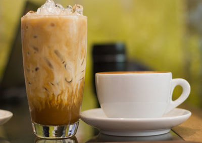 Close-up of iced and hot coffee on restaurant table