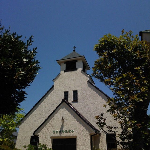 building exterior, architecture, built structure, low angle view, clear sky, tree, blue, religion, place of worship, church, spirituality, house, sunlight, high section, window, sky, day, outdoors