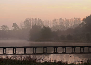 Scenic view of river against sky during foggy weather