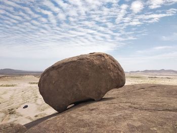 Rocks on sand against sky