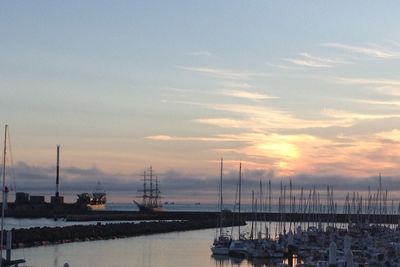 Boats in harbor at sunset