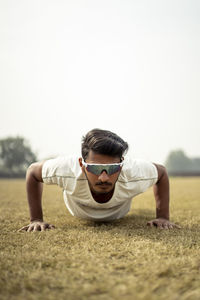 Close up portrait of a young indian sportsman exercising in the field. sportsman doing push ups