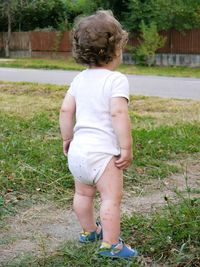 Rear view of boy standing in grass