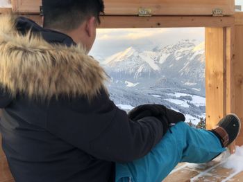 Rear view of man with snowcapped mountains in winter