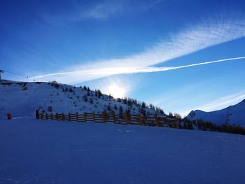 Scenic view of snow covered mountains against blue sky