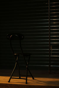 Empty chair on road against shutter