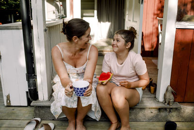 Happy friends sitting outdoors