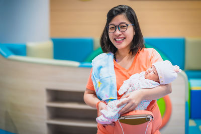 Portrait of smiling mother carrying daughter