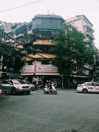 Cars on road against sky in city