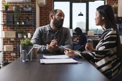 Business people talking while sitting at office