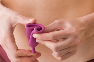 Midsection of woman holding menstrual cup