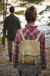 Rear view of couple hiking in forest