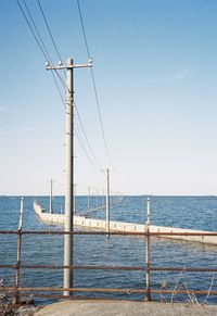 Utility pole leading to the sea
