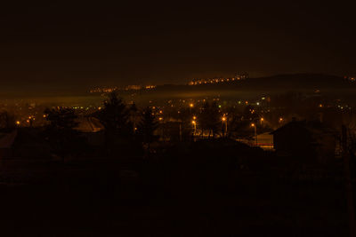 Illuminated cityscape against sky at night