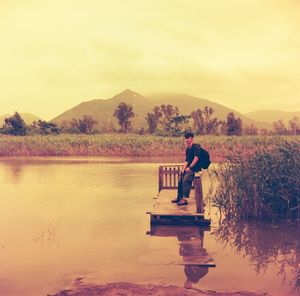 Man on lake against sky