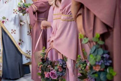 Midsection of bridesmaid holding flowers in wedding