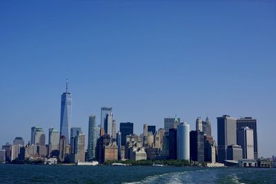 Buildings in city against clear blue sky