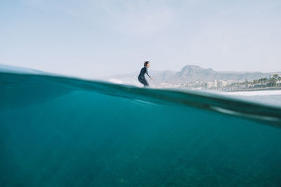 Split image of female surfer surfing a wave on a sunny day