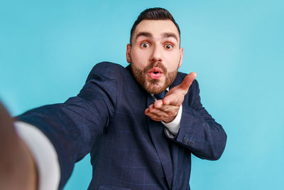 Man blowing kiss against blue background