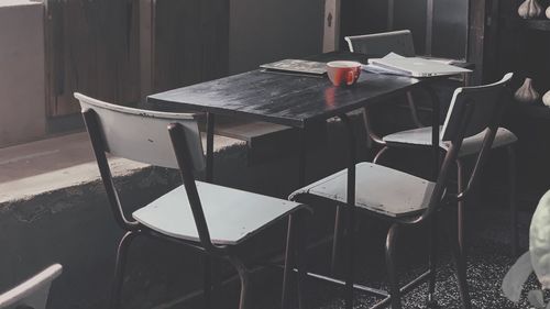 Empty chairs and table in building