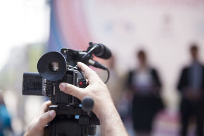 Cropped hand of man operating movie camera