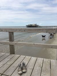 People at sea shore against sky