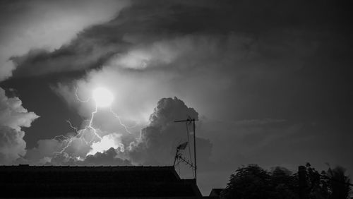 Low angle view of silhouette trees against sky at night