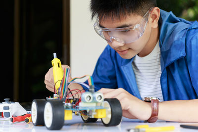 Teenager boy working on robotic toy