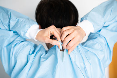 Rear view of child holding hands on bed