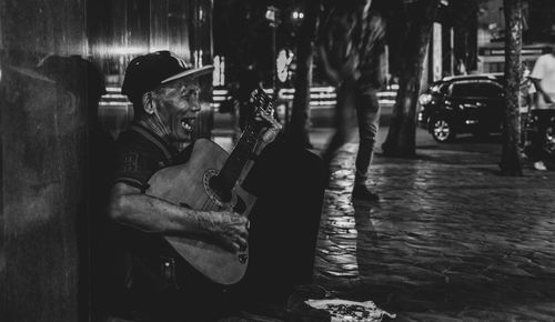 Man sitting on street at night