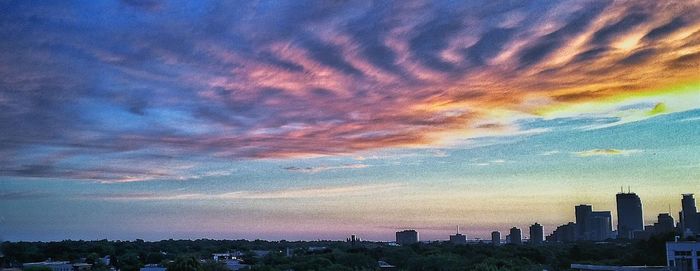 Cityscape against cloudy sky